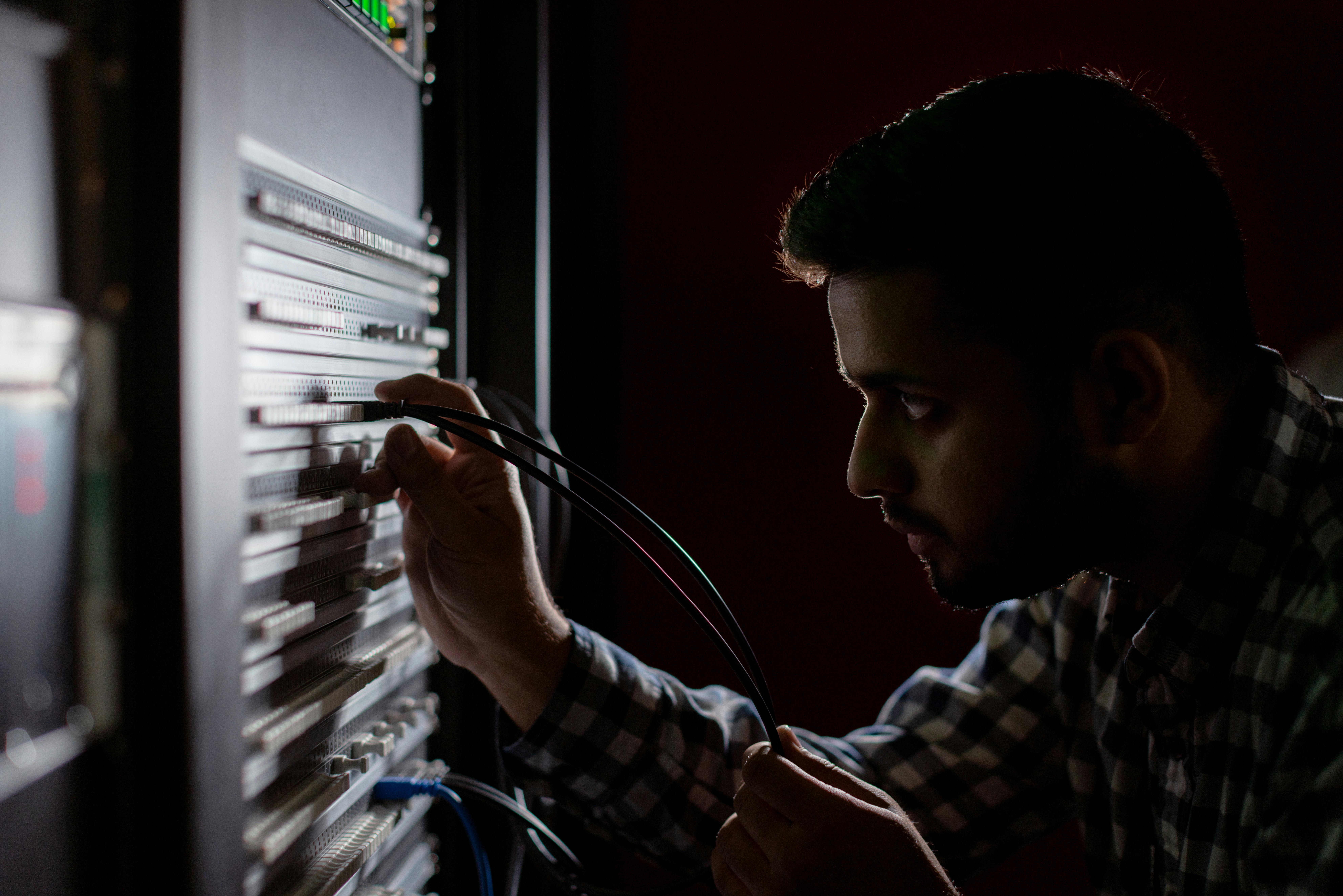 Network engineer connecting cables inside a server rack