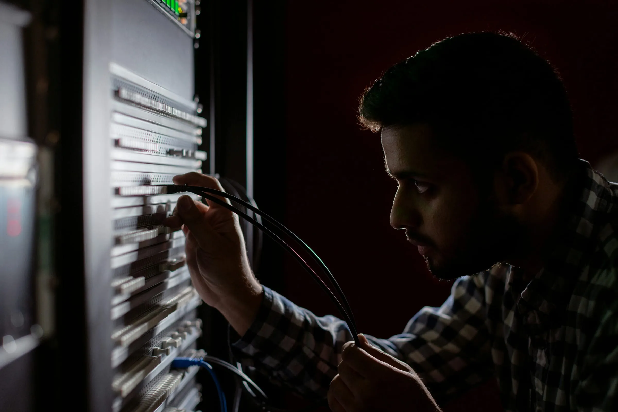 Network engineer connecting cables inside a server rack